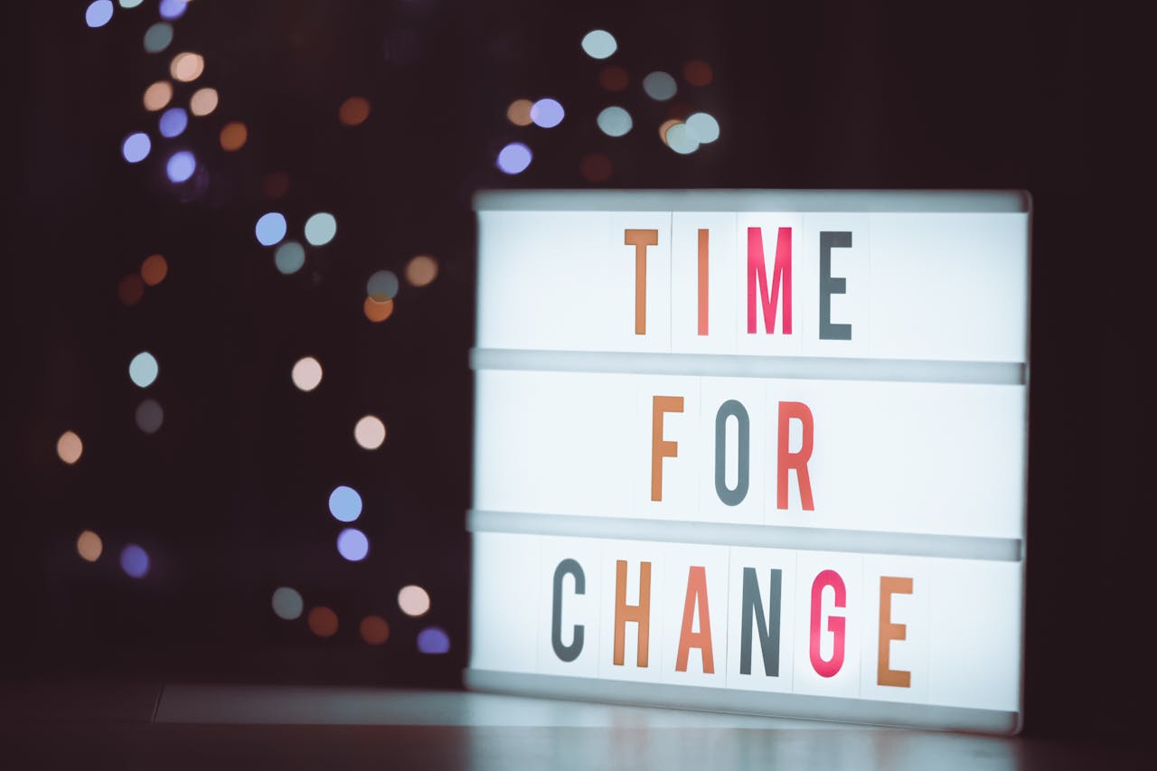 Illuminated lightbox sign displaying 'Time for Change' with a bokeh background, conveying transformation.